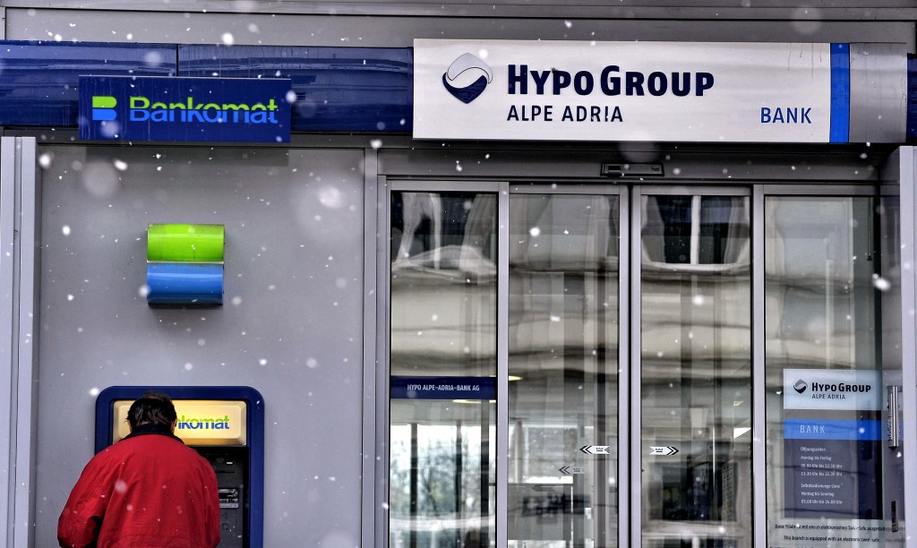 A customer uses an ATM at a Hypo Group Alpe Adria Bank (HGAA) branch in Klagenfurt, Austria, on Wednesday, Dec. 16, 2009. Bayerische Landesbank Chief Executive Officer Michael Kemmer resigned after the lender had to write off its investment in Hypo Alpe-Adria Bank International AG. Photographer: Guenter Schiffmann/Bloomberg via Getty Images