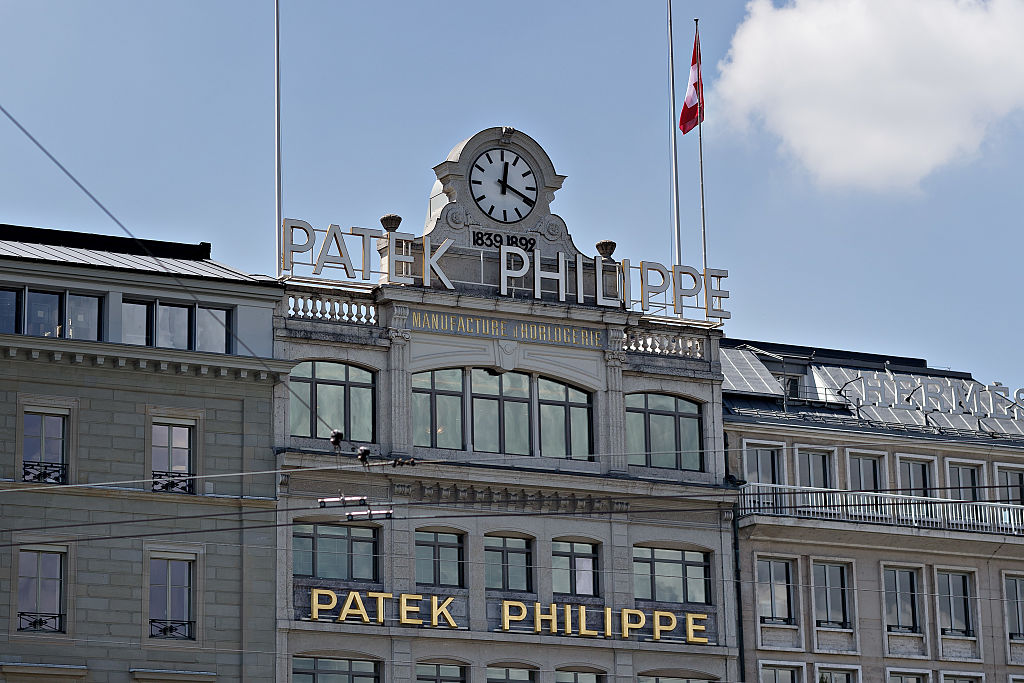 A company logo sits above the Patek Philippe SA luxury watch retailer in Geneva, Switzerland on Tuesday, June 8, 2016. North American and European banks are quitting Geneva as companies battle with the loss of financial secrecy, the strong Swiss franc and pressure on profitability from low interest rates and tougher regulatory demands. Photographer: Michele Limina/Bloomberg via Getty Images