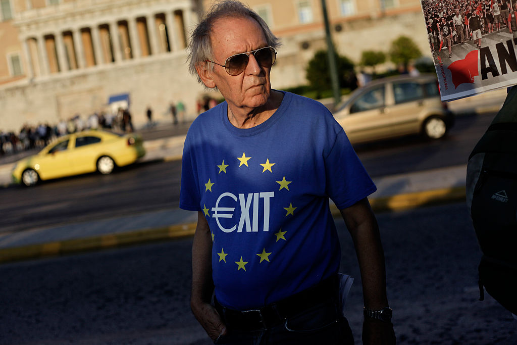 A man wearing a t-shirt with the EU flag and the word Exit depicting the Euro sign during a demonstration for one year after the Greek referendum. Athens, July 5, 2016. (Photo by Kostis Ntantamis/NurPhoto via Getty Images)