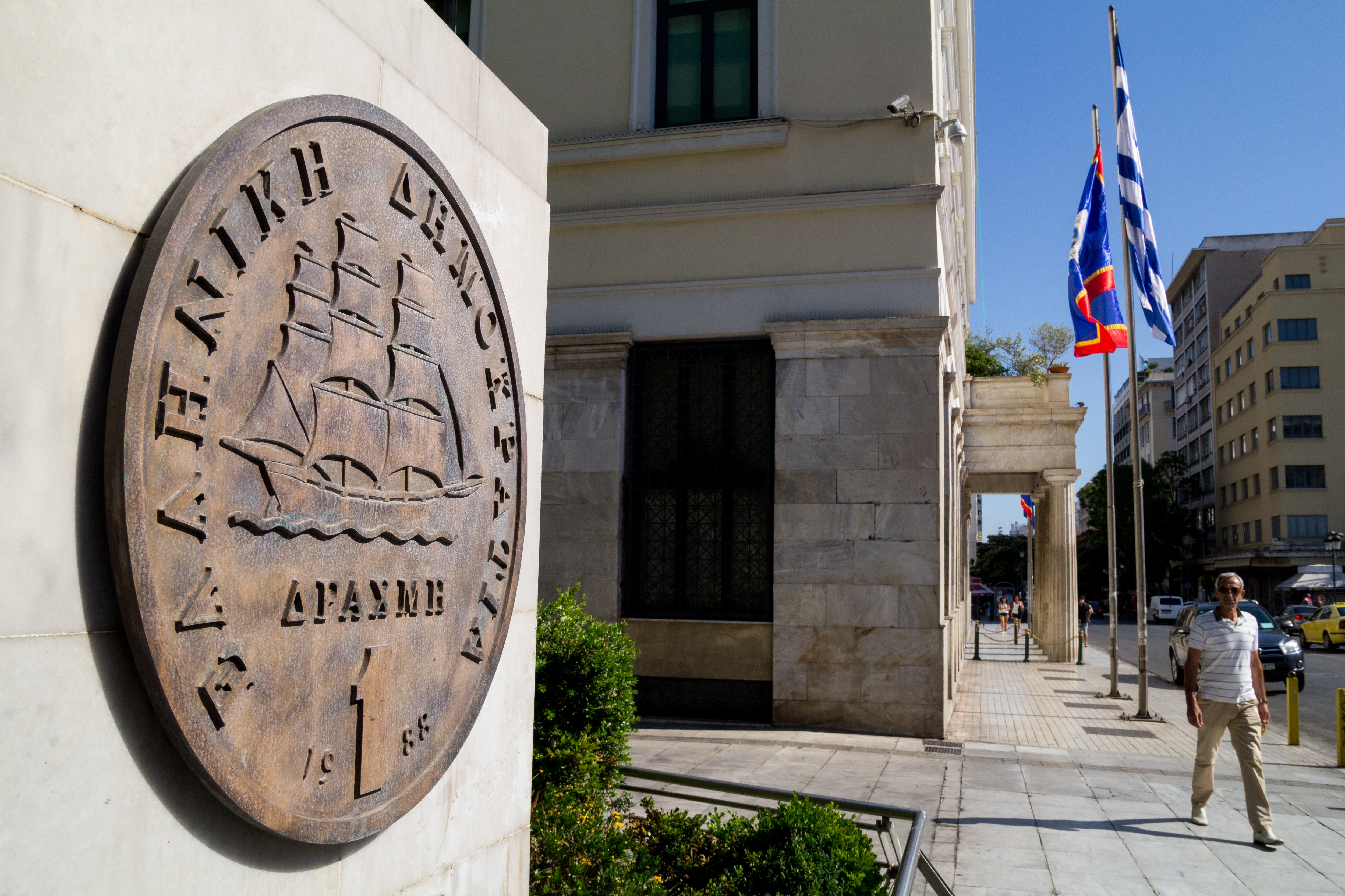 ATHENS, GREECE - 2015/07/05: A man walks in front of a Greek Drachma sculpture, near Athens City Hall. The ongoing referendum is said that will risk Greece's Eurozone future with a possible "No", bringing the country back to Drachma. (Photo by Kostas Pikoulas/Pacific Press/LightRocket via Getty Images)