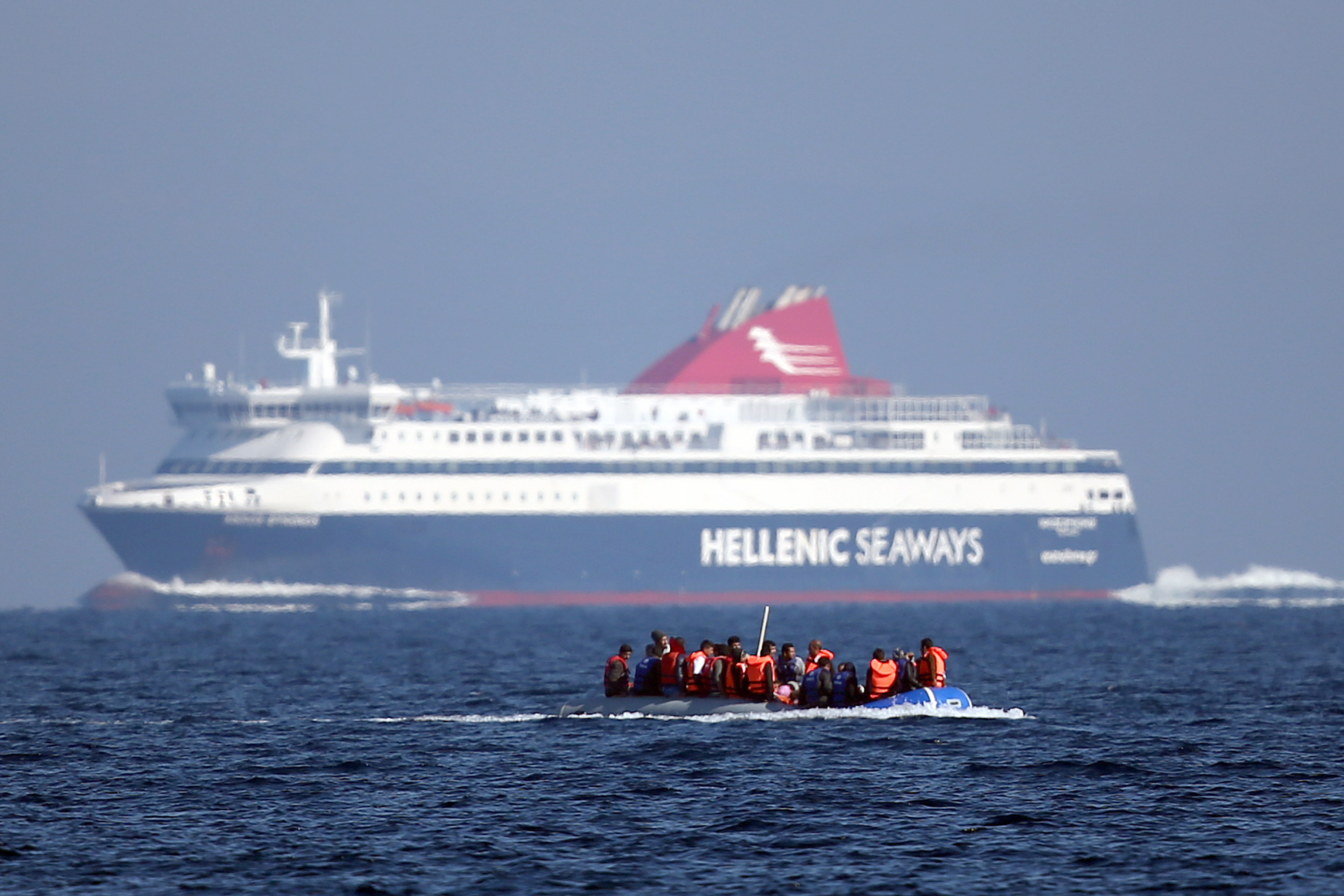 SIKAMINIAS, GREECE - NOVEMBER 14: A migrant boat passes a passenger ferry as it makes the crossing from Turkey to the Greek island of Lesbos on November 14, 2015 in Sikaminias, Greece. Rafts and boats continue to make the journey from Turkey to Lesbos each day as thousands flee conflict in Iraq, Syria, Afghanistan and other countries. Over 500,000 migrants have entered Europe so far this year and approximately four-fifths of those have paid to be smuggled by sea to Greece from Turkey, the main transit route into the EU. Most of those entering Greece on a boat from Turkey are from the war zones of Syria, Iraq and Afghanistan. (Photo by Carl Court/Getty Images)